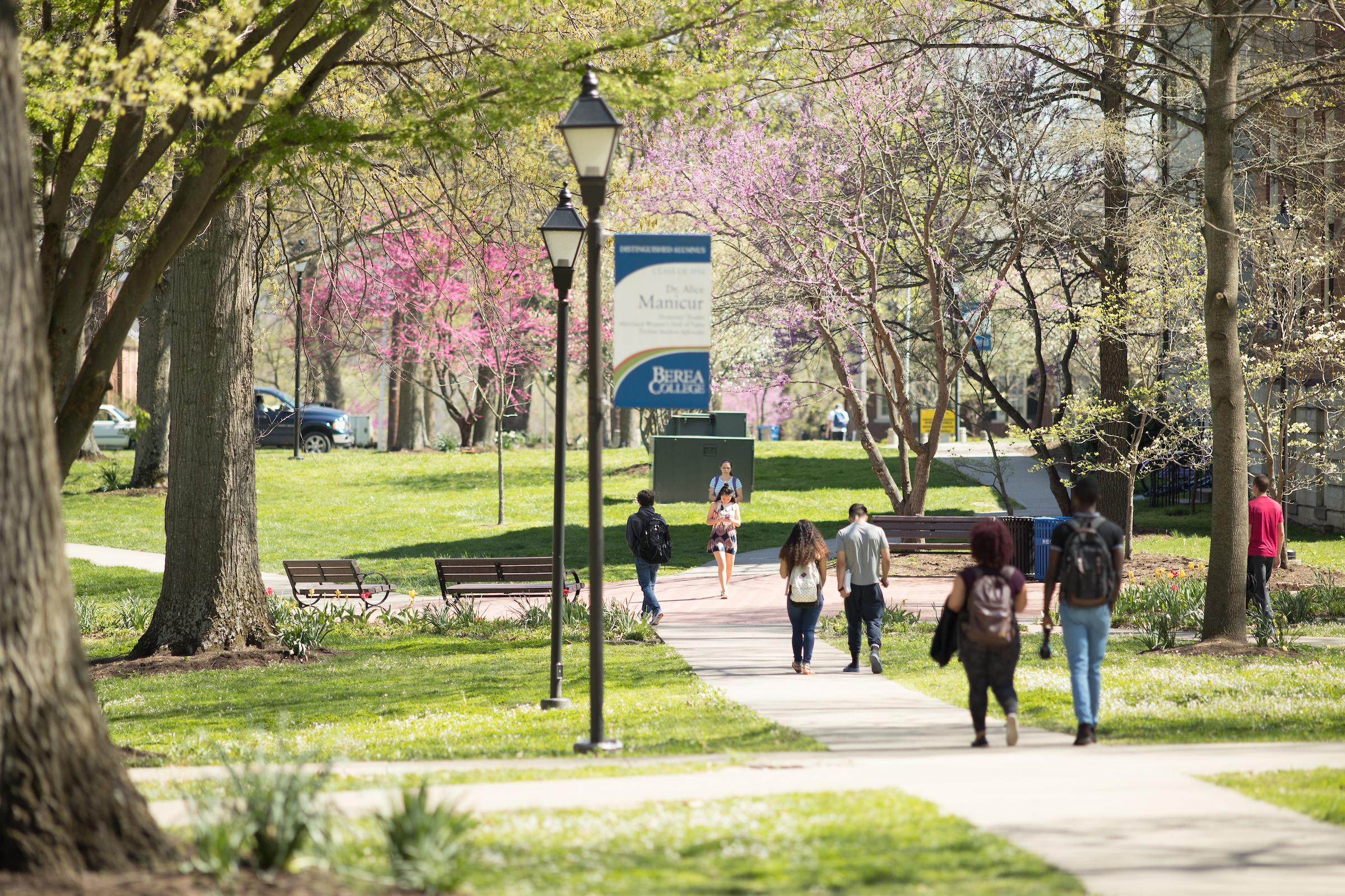 Outdoor campus image of students walking on the sidewalks throughout campus.